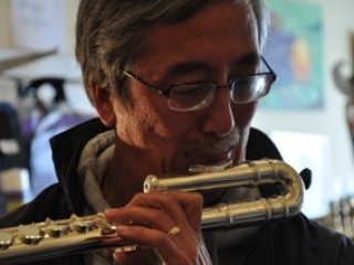 Bob Kenmotesu tries out a flute at Steve Deutsch Woodwinds